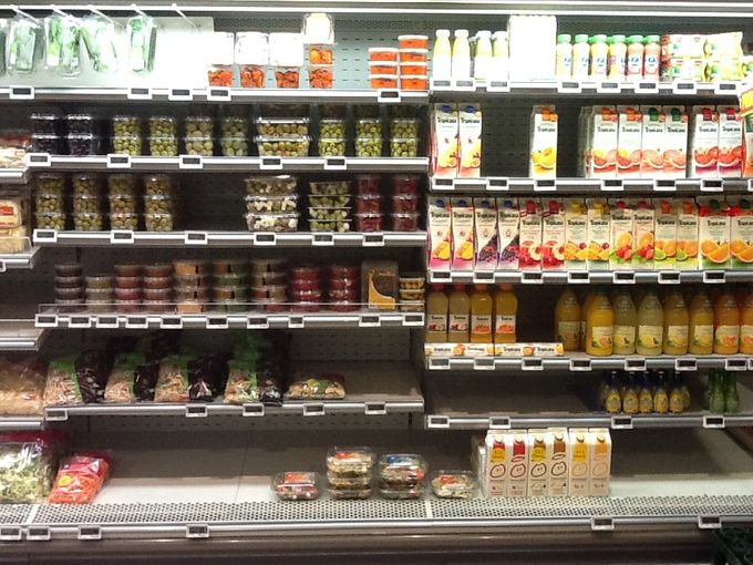 Assortiment olijven en ander specialiteiten in potjes in supermarkt.